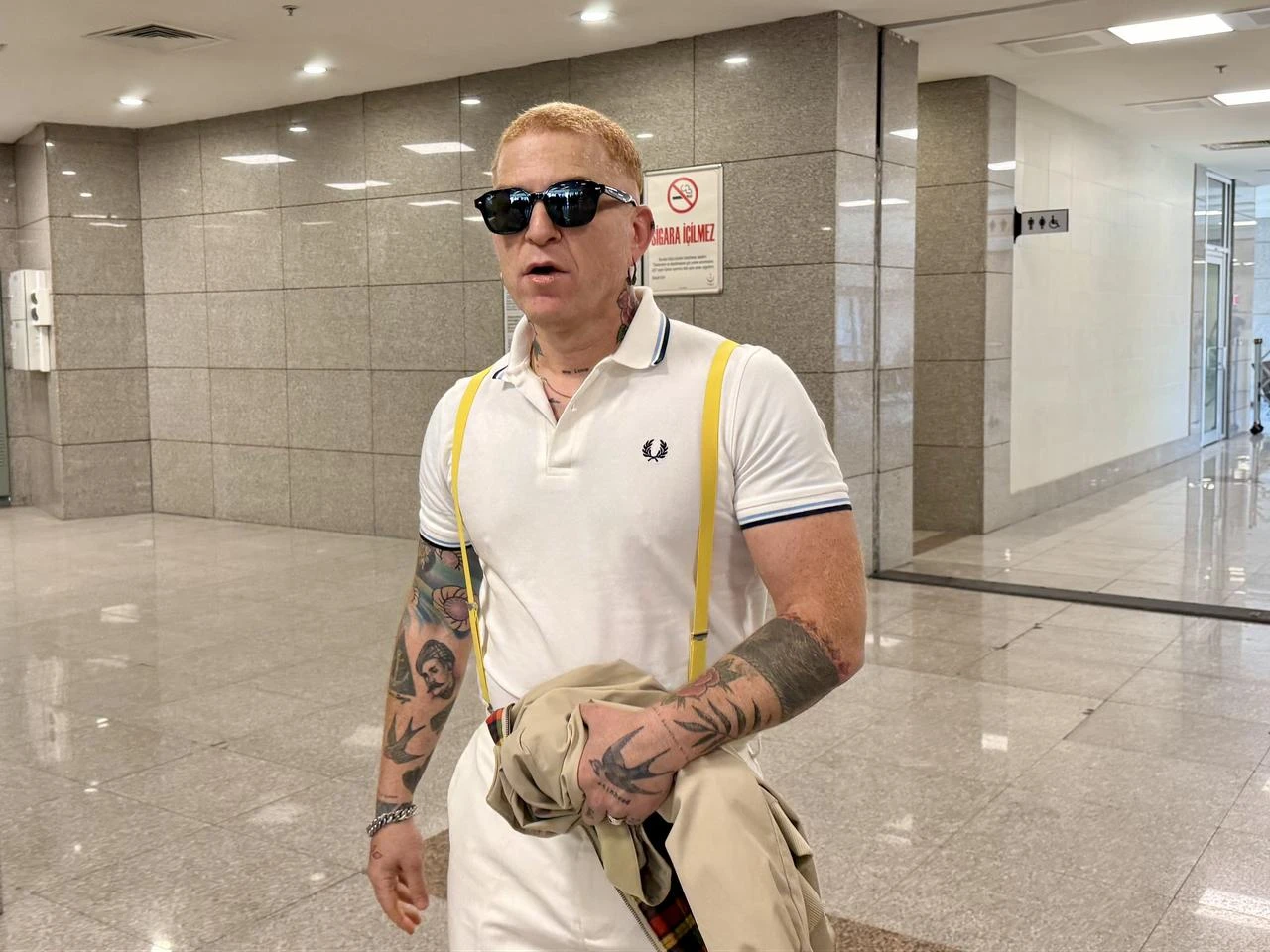 Gokhan Ozoguz walks through a courthouse corridor after being called to give a statement in an investigation involving the Ahbap Association, July 22, 2026. (AA Photo)