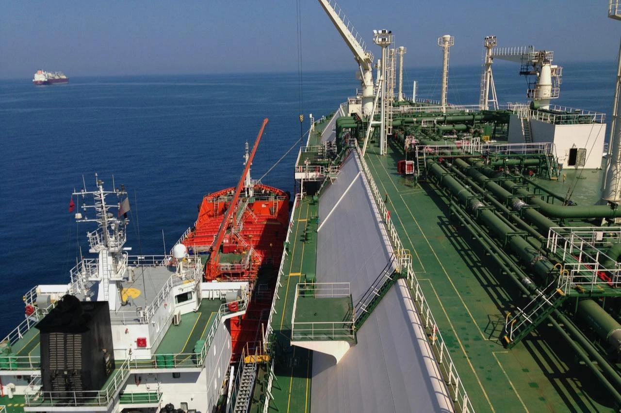 A liquefied natural gas (LNG) carrier receives fuel from a bunkering vessel at sea. (Adobe Stock Photo)