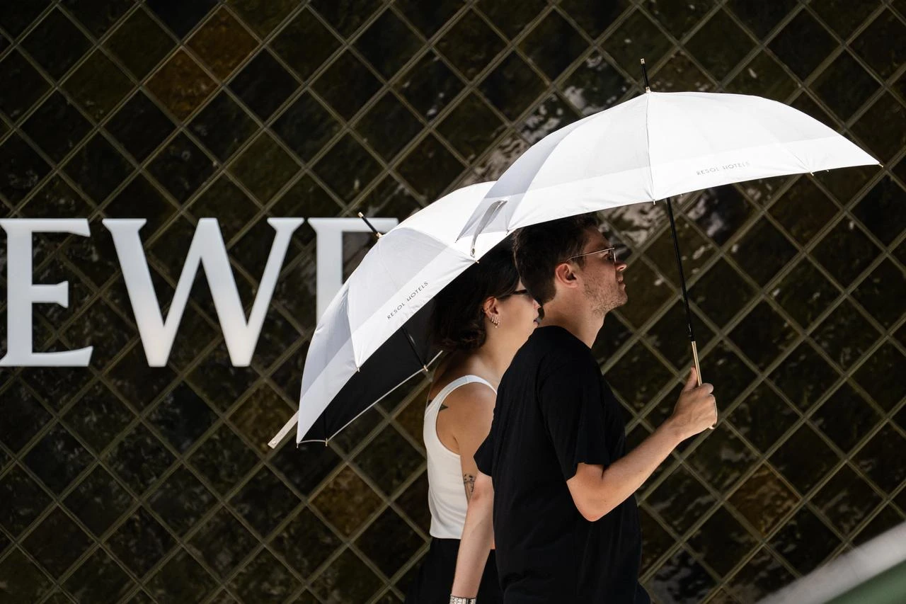 Tourists use umbrellas to shelter from the sun in Tokyo on July 23, 2026. (AFP Photo)