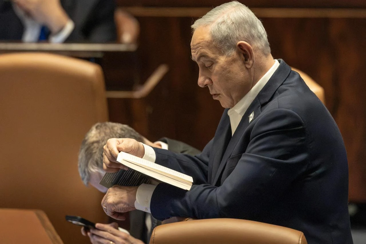 Israel's Prime Minister Benjamin Netanyahu reads a book at the Knesset during a session of the Israeli Parliament in Jerusalem on July 16, 2026. (AFP Photo)