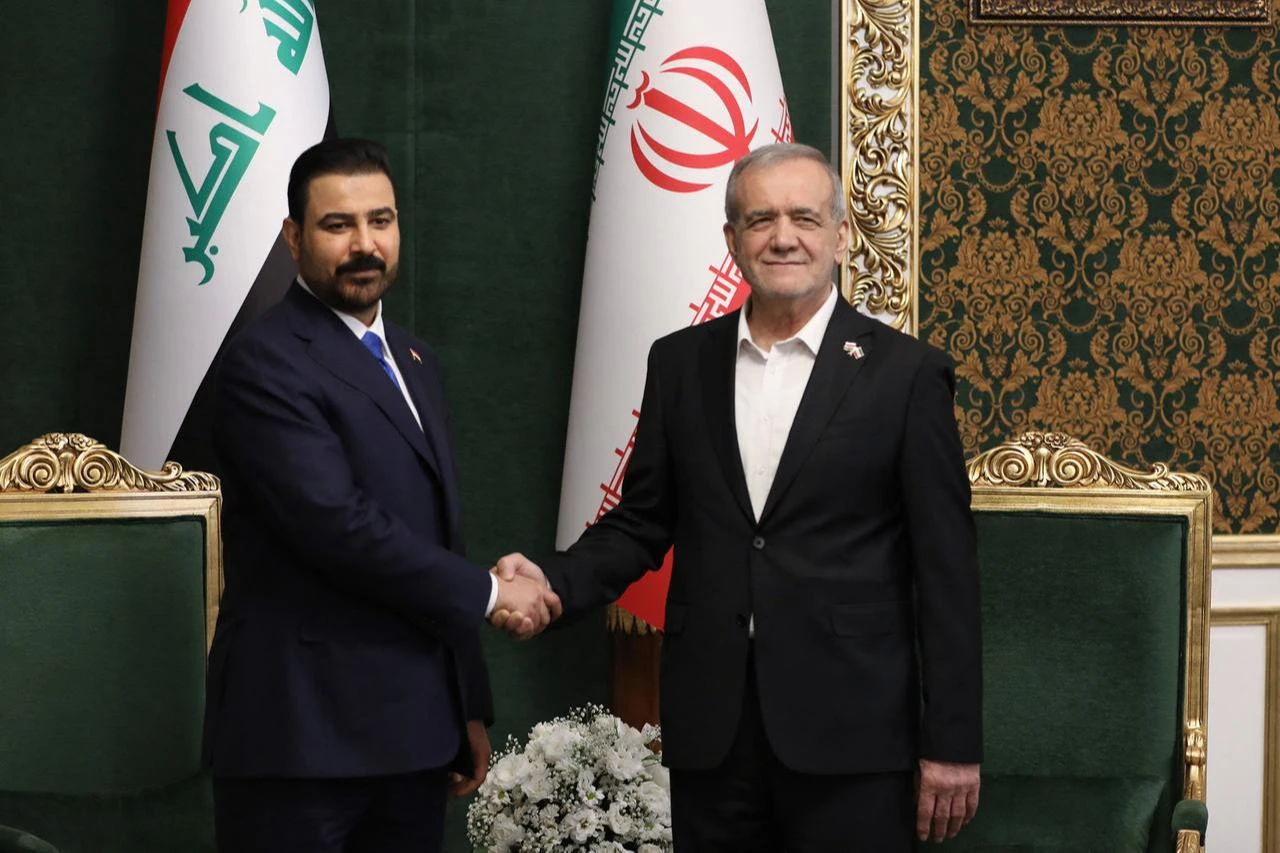 A handout picture provided on July 23, 2026, shows Iranian President Masoud Pezeshkian (R) shaking hands with Iraqi Prime Minister Ali al-Zaidi in the Iranian capital Tehran. (AFP Photo/Iranian Presidency/Handout)