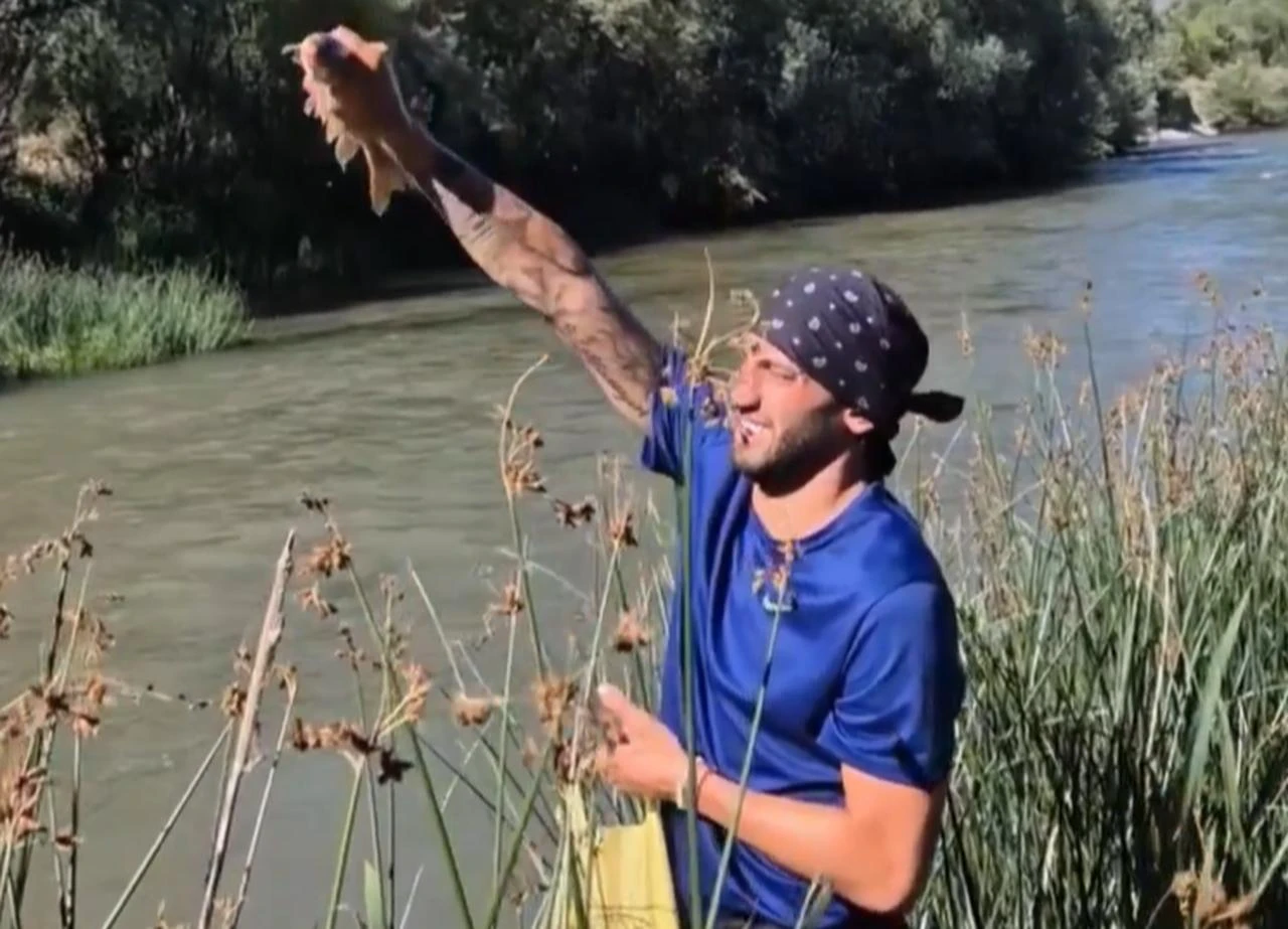 Türkiye international Hakan Calhanoglu holds up a fish during his village holiday in Bayburt, Türkiye. (Photo via X/@bionmedya)