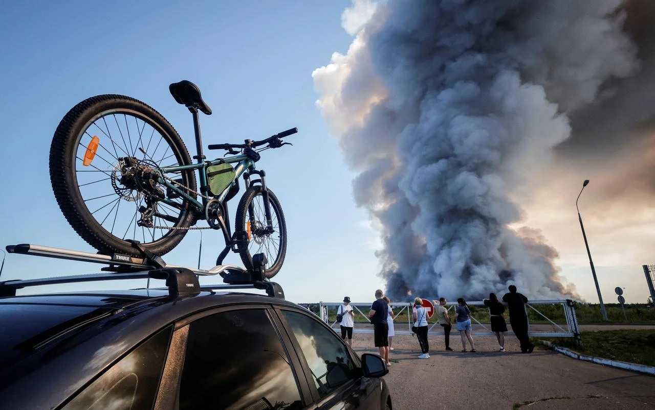 Bystanders watch as smoke rises from a fire at the Russian e-commerce firm Wildberries' logistics complexes in the town of Elektrostal outside Moscow on July 18, 2026. (AFP Photo)