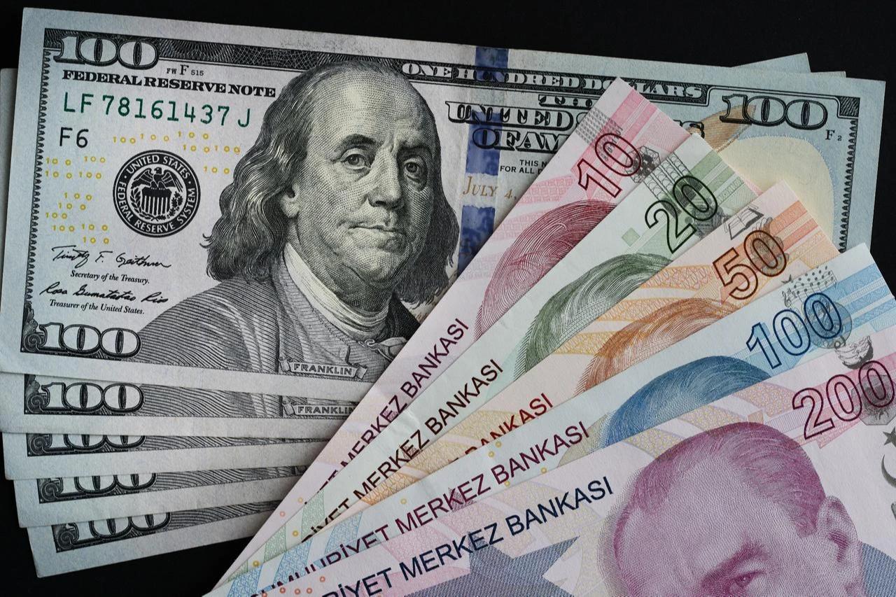Photo illustration shows U.S. dollar banknotes alongside Turkish lira notes. (Adobe Stock Photo)