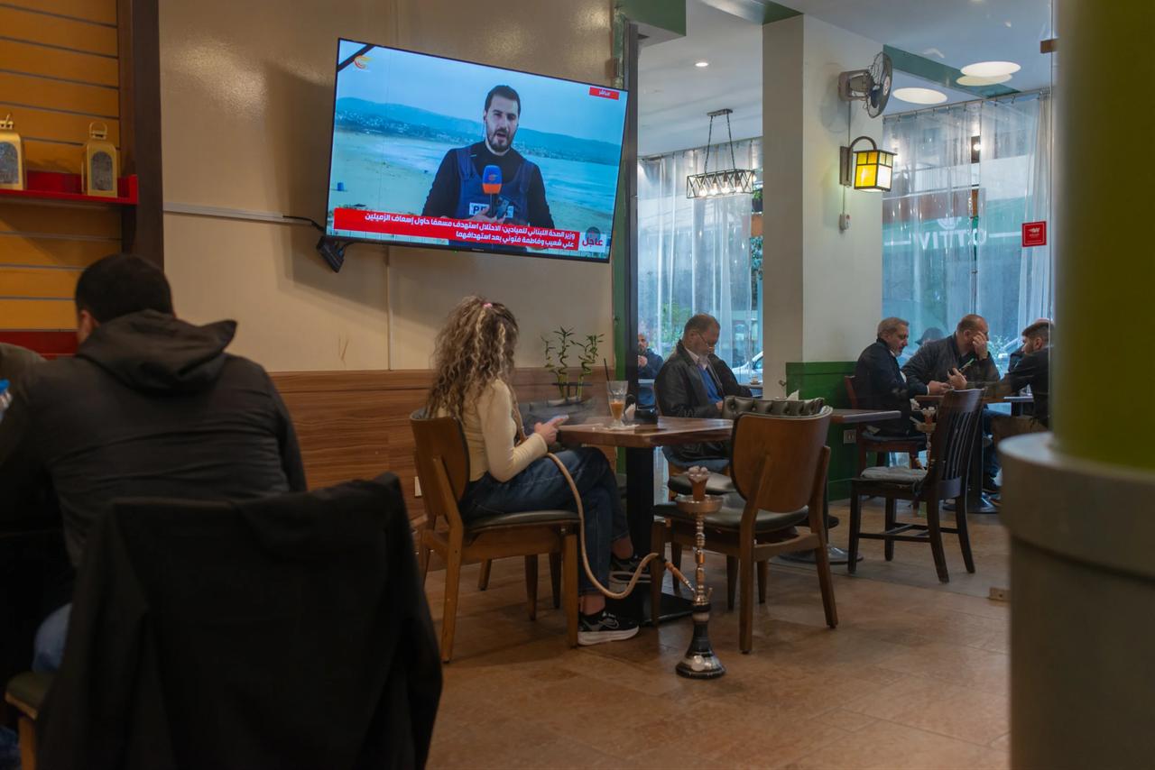 Customers watch a television news broadcast inside a cafe in Beirut's Hamra district, Lebanon, on March 28, 2026. (Photo by Segolene Ragu/L'Orient Today)
