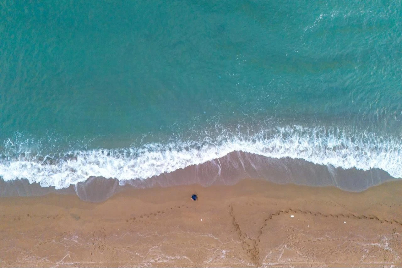 Aerial view shows the sandy shoreline of Karasu in Sakarya province meeting turquoise waves along the Black Sea coast near Adapazari, Türkiye. (Adobe Stock Photo)