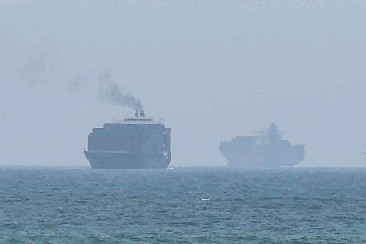 This frame grab taken from AFPTV video footage on July 12, 2026 shows cargo ships anchoring near the Strait of Hormuz off the eastern coast of the United Arab Emirates at Khor Fakkan. (AFP Photo)