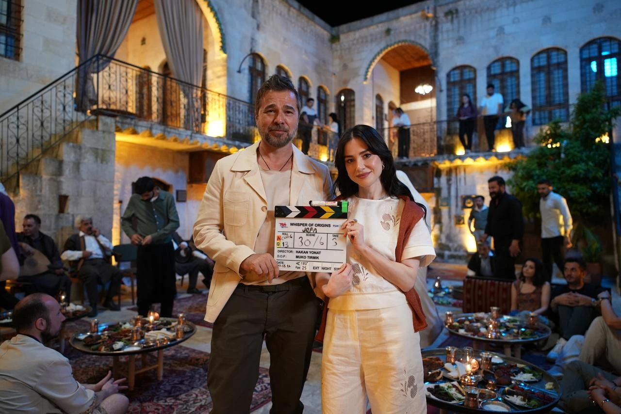 Actors Engin Altan Duzyatan and Ozge Gurel pose with the clapperboard during the filming of GO Türkiye's new mini-series Whispers of Origins, shot across southeastern Türkiye. (AA Photo)