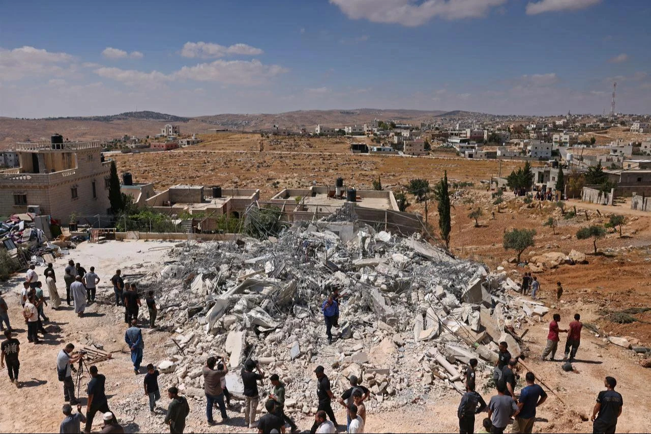 People gather around the rubble of a Palestinian home demolished by Israeli forces after being reportedly built without a permit in the village of al-Rifayia, south of Hebron in the occupied West Bank, July 9, 2026. (AFP Photo)