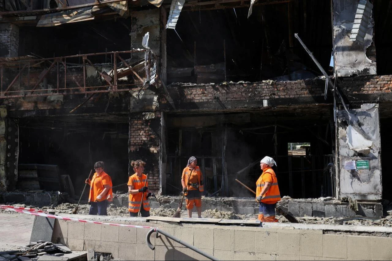 Communal workers clear debris near a shopping mall damaged by missile strikes in Kyiv on July 19, 2026, amid the Russian invasion of Ukraine. (AFP Photo)