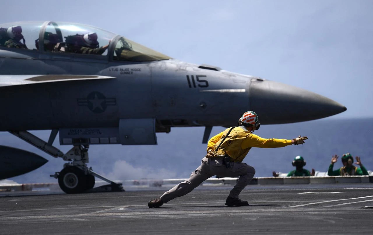 A US Navy aviation boatswain’s mate directs a F/A-18F Super Hornet assigned to Strike Force Squadron (VFA) 154 on the flight deck aboard the aircraft carrier USS Theodore Roosevelt (CVN-71) while the ship is moored in Honolulu, Hawaii, during Exercise RIMPAC (Rim of the Pacific) 2026 on July 17, 2026. (AFP Photo)