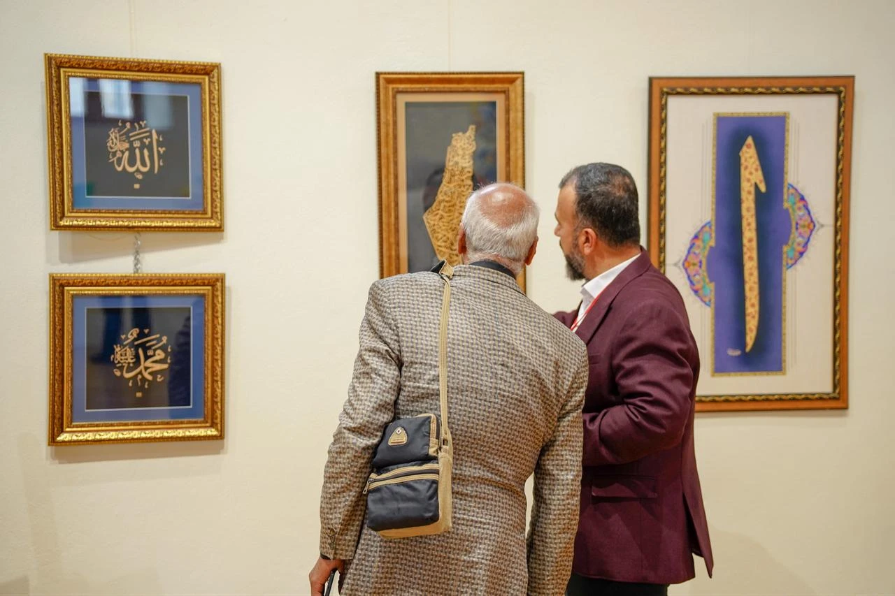 Visitors examine calligraphy works during the 8th Turkish-Arab Artists Meeting at Rami Library in Istanbul, Türkiye, July 25, 2026. (AA Photo)