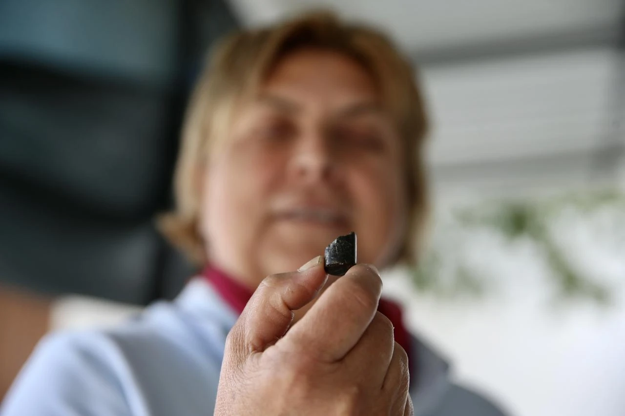 Professor Aysegul Aykurt displays a small piece of obsidian recovered at the site in southwestern Türkiye. (AA Photo)