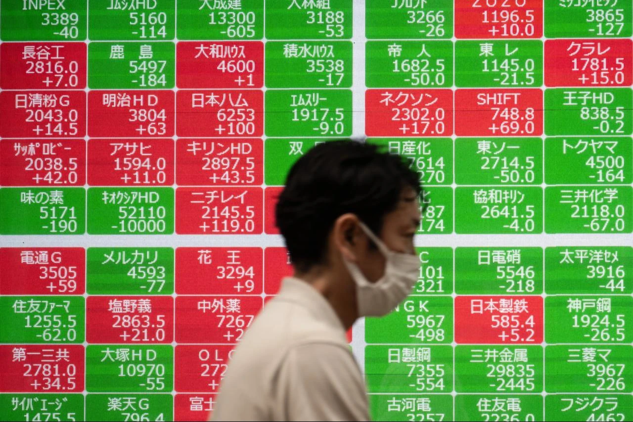 A pedestrian walks past an electronic quotation board displaying the Nikkei Stock Average on the Tokyo Stock Exchange in Tokyo, July 17, 2026. (AFP Photo)