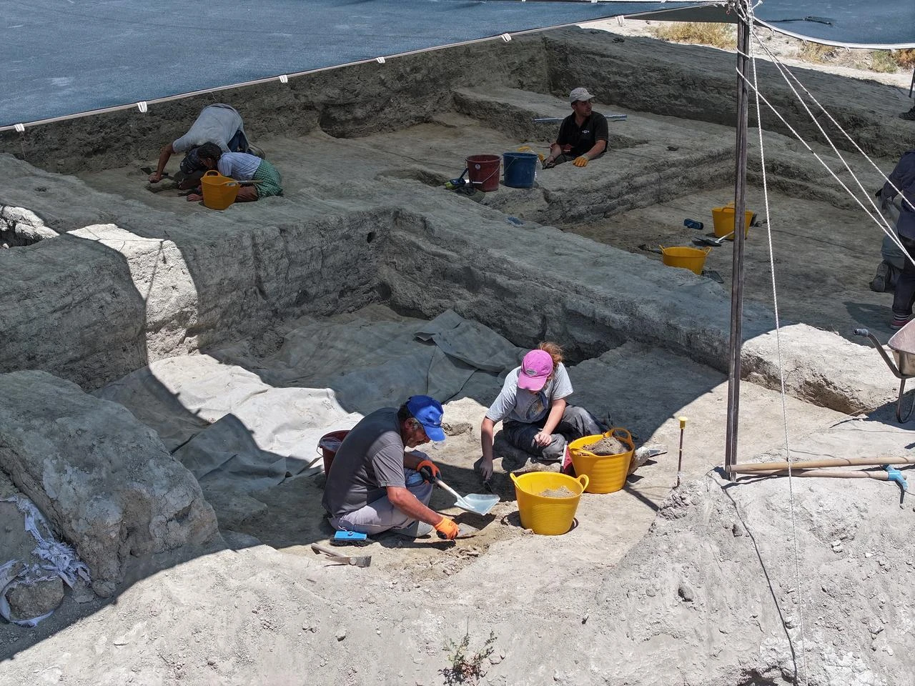 Archaeologists work in a shaded excavation trench at Turkmen Karahoyuk in Konya, Türkiye. (AA Photo)