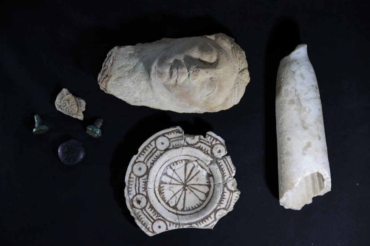 A selection of artifacts uncovered during excavations at Turkmen Karahoyuk is displayed against a dark background. (AA Photo)