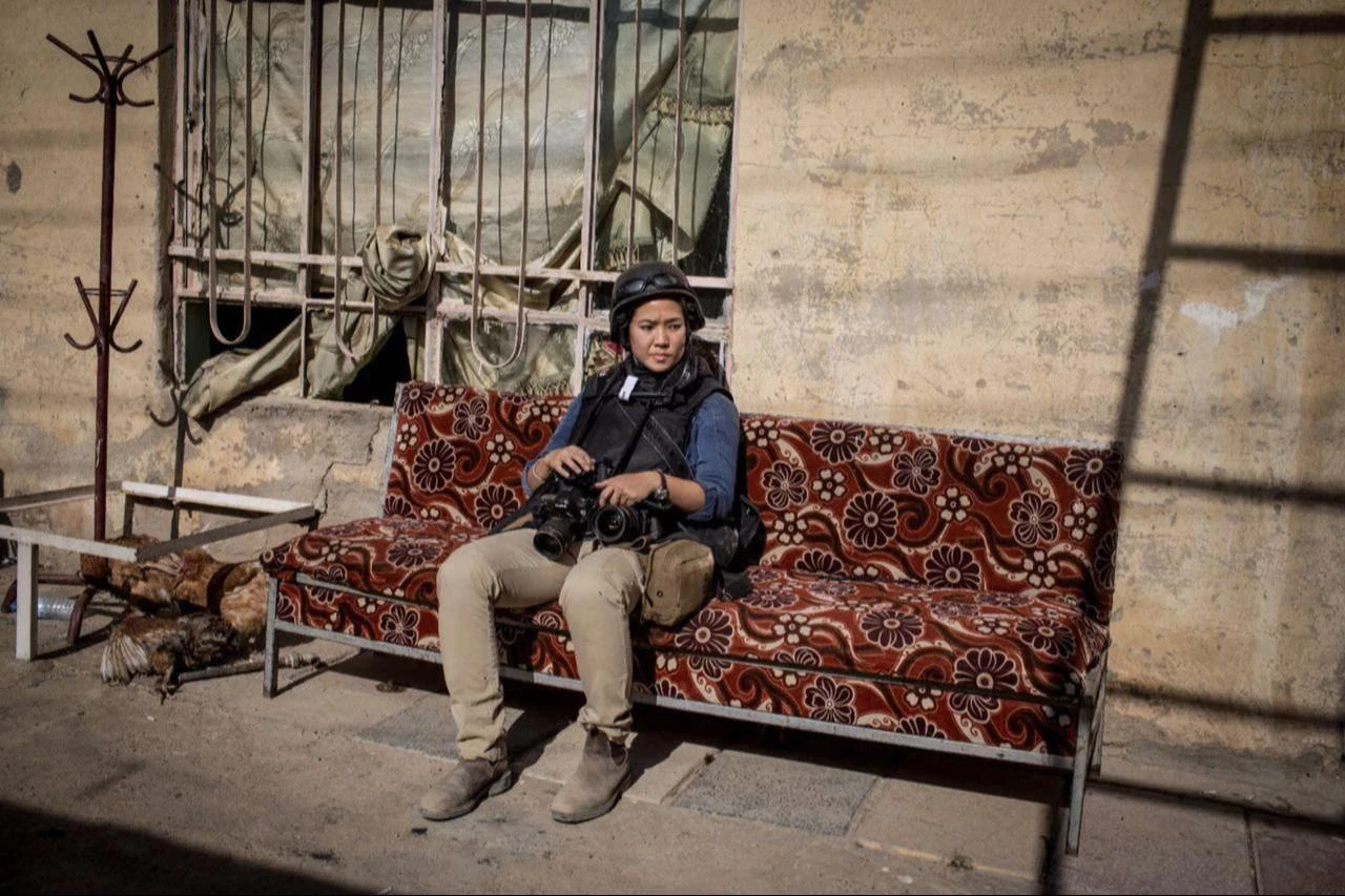 Photojournalist Nicole Tung sits with her cameras during field coverage, reflecting the realities of reporting from conflict zones date and time undisclosed. (Photo via New York University)