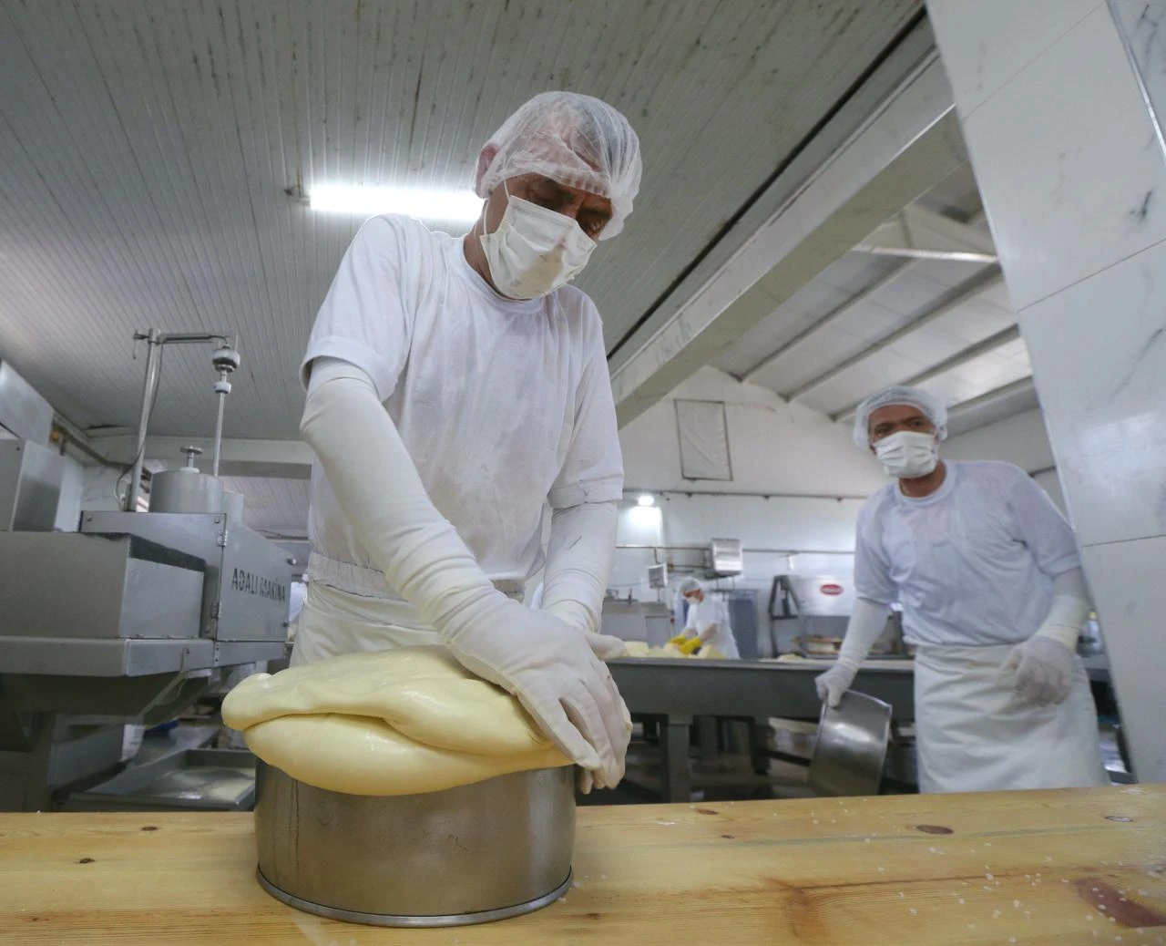 A worker presses and shapes cheese by hand at a production facility in Kars, Türkiye, July 27, 2026. (AA Photo)