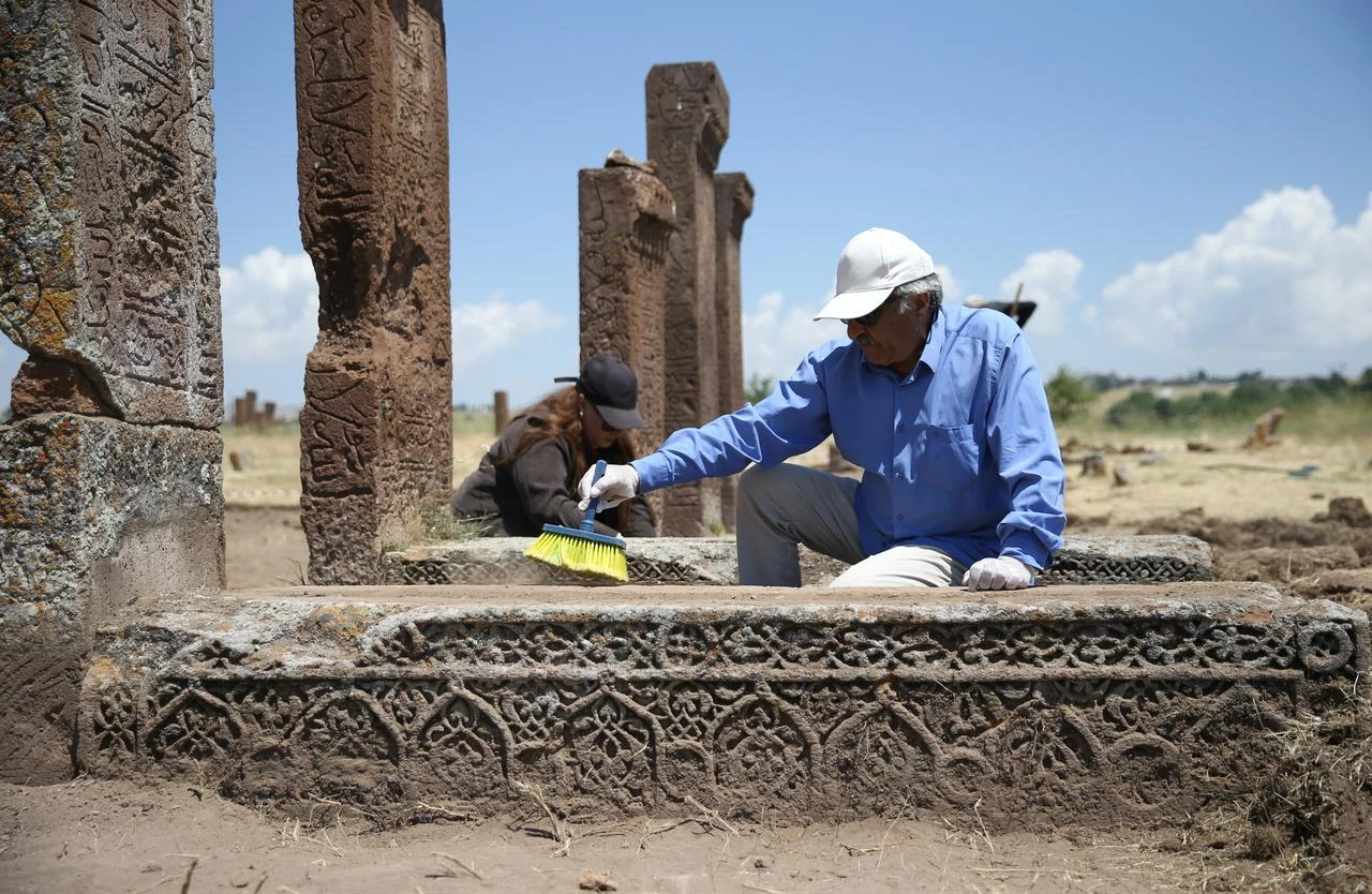 Researchers clean an ornamented grave during excavation and conservation work at the Seljuk Square Cemetery in Ahlat, Bitlis, Türkiye, July 28, 2026. (AA Photo)