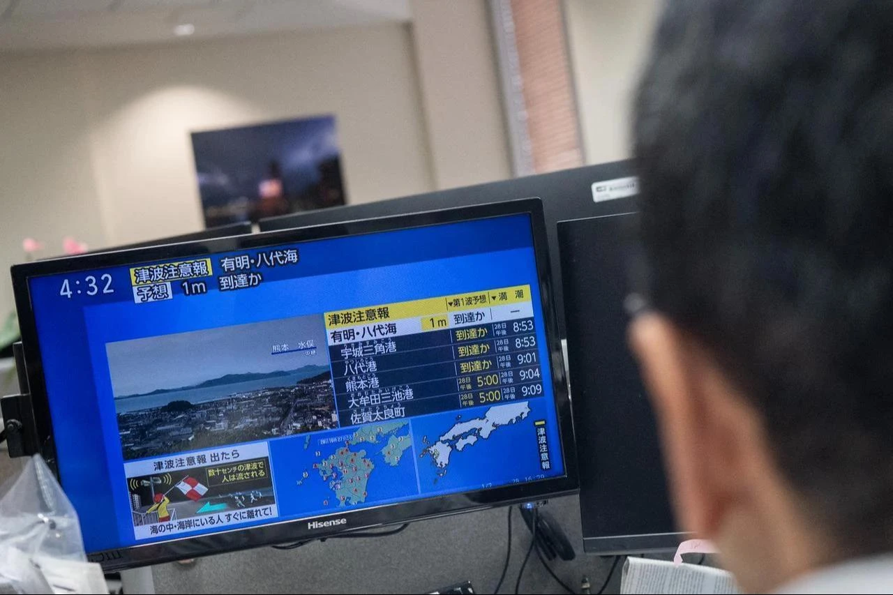 Reporters watch the news showing a large quake and possible one meter tsunami wave in Southern Japan, from an office in Tokyo on July 28, 2026. (AFP Photo)