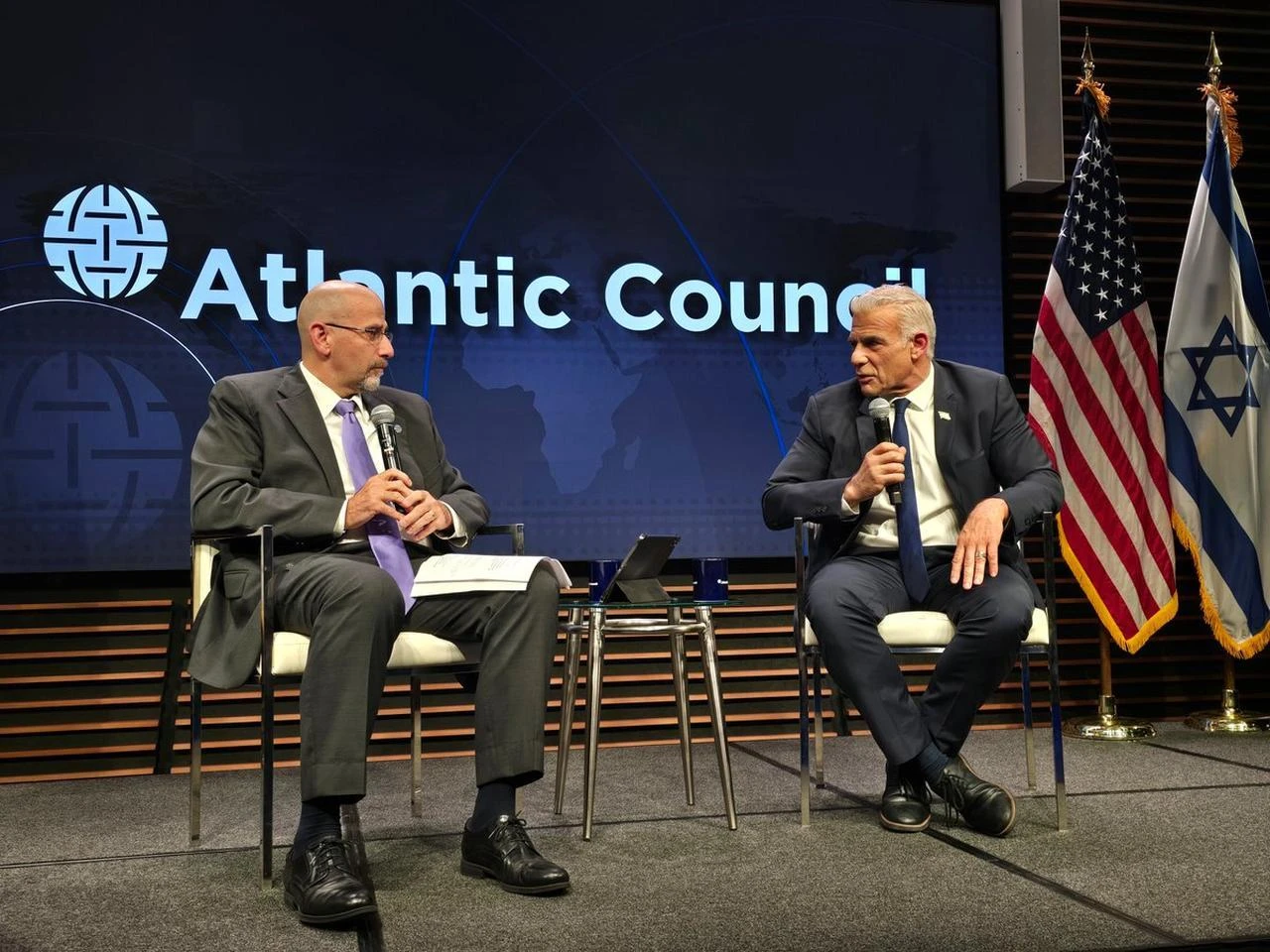 Israeli Opposition Leader Yair Lapid (R) speaks alongside former US Ambassador to Israel Daniel Shapiro (L) during a fireside chat on the future of Israel and the region at the Atlantic Council in Washington on July 27, 2026.