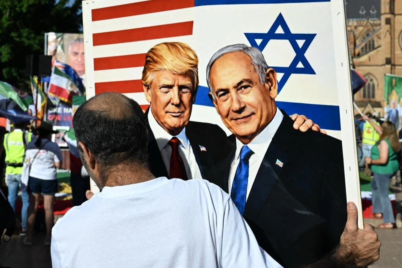 A member of the Iranian community in Australia holds a placard in support of US President Donald Trump and Israeli Prime Minister Benjamin Netanyahu during a rally in Sydney, March 14, 2026. (AFP Photo)