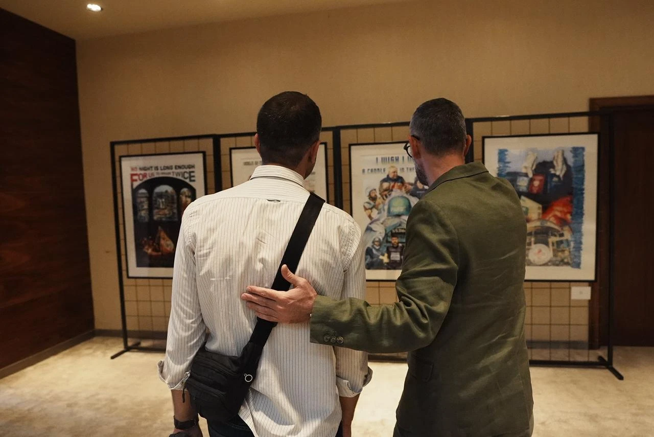 Visitors look at works from Turkish artist Ahmet Yusuf Aygec's "Posters to the Olive Tree in Exile" exhibition at the Mahmoud Darwish Museum in Ramallah. (AA Photo)