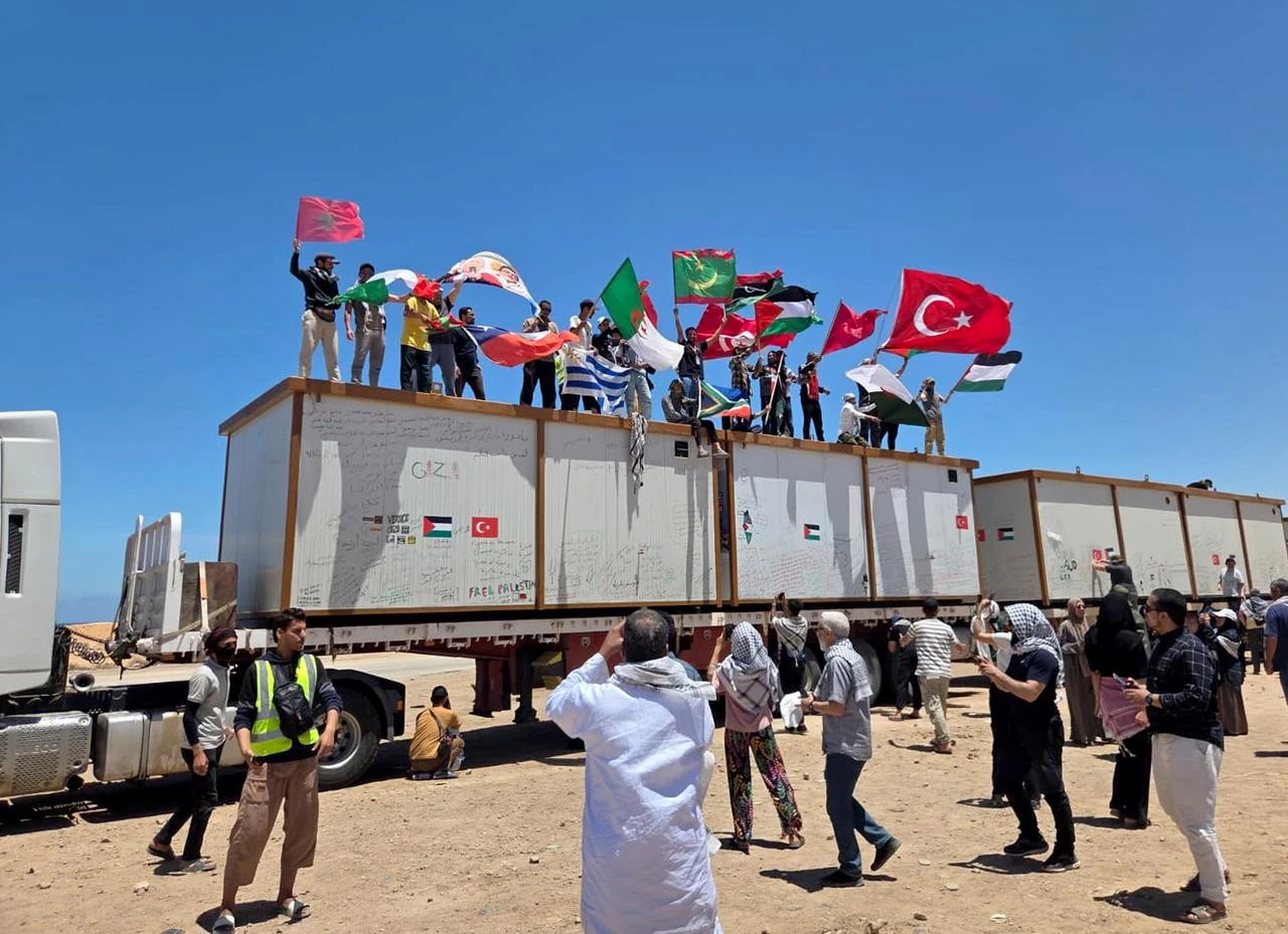 People wave flags of Turkiye, Palestine, Morocco as Global Sumud Flotilla convoy, which set out by land to break the blockade on Gaza and deliver humanitarian aid, continues to wait near Libya's Sirte for 4 days, May 20, 2026. (AA Photo)