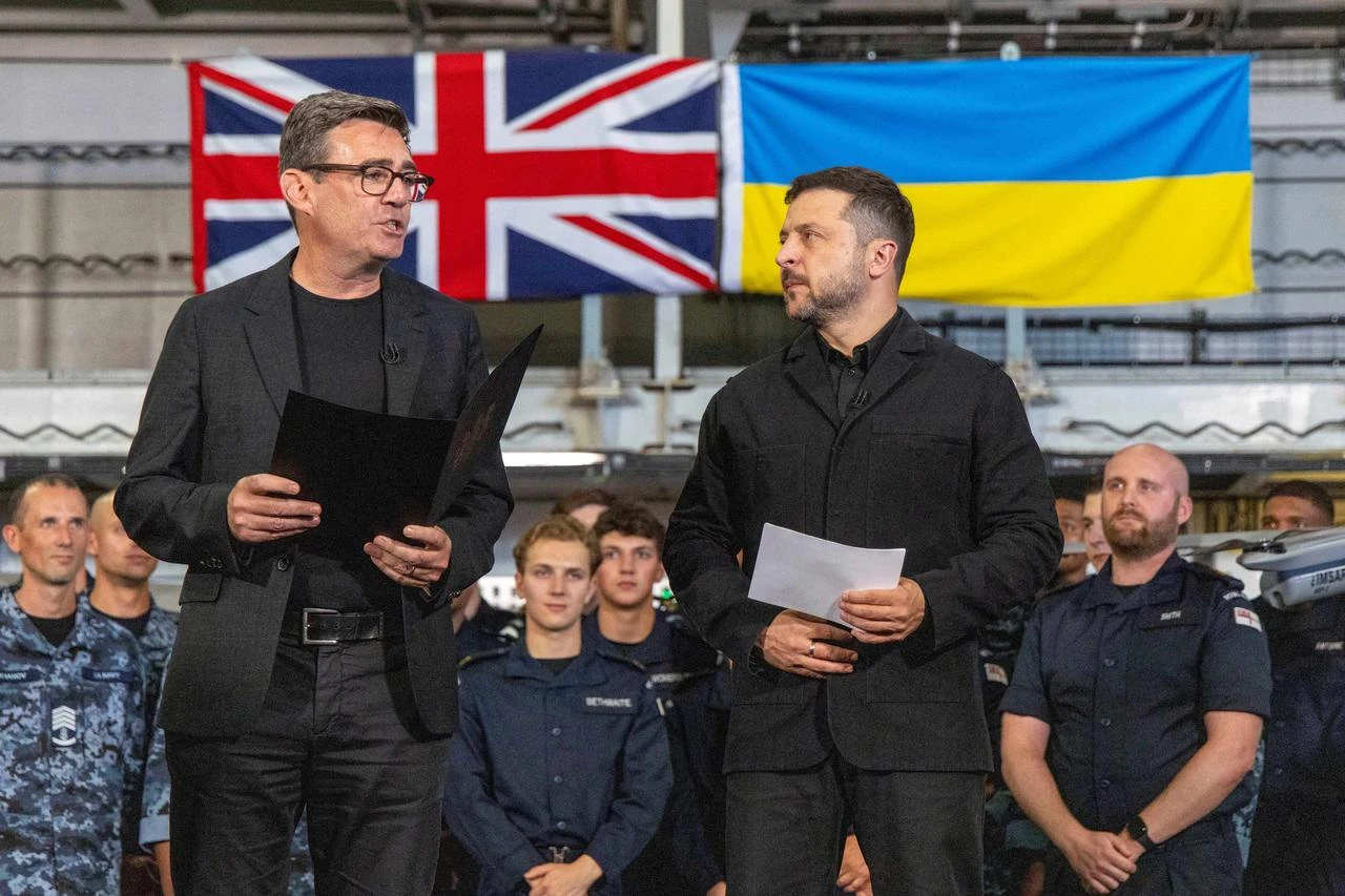 Britain's Prime Minister Andy Burnham (L) and Ukraine's President Volodymyr Zelensky (R) speak to troops on board the Royal Navy aircraft carrier HMS Queen Elizabeth during their visit to HM Naval Base in Portsmouth on the south coast of England on July 27, 2026. (AFP Photo)