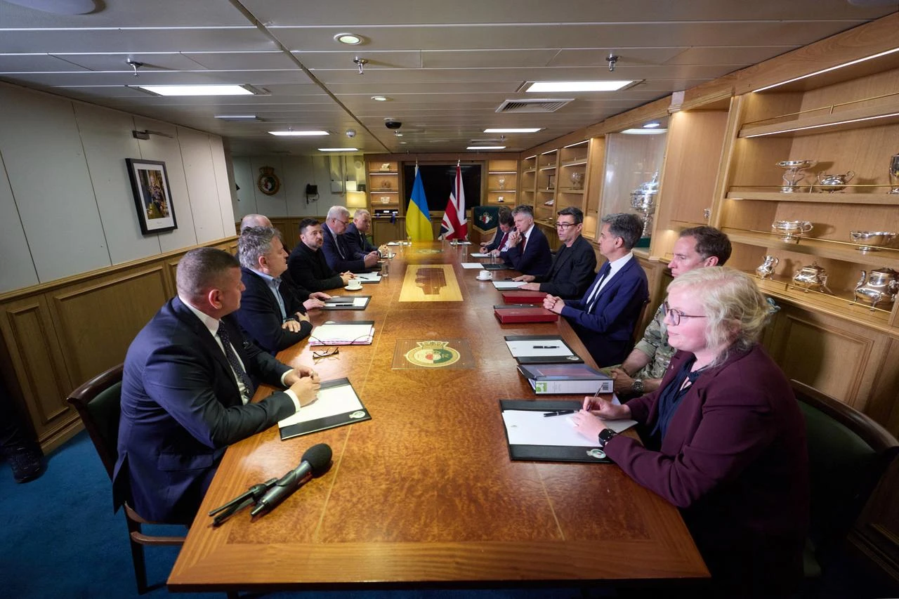 This handout photograph taken and released by the Ukrainian Presidential Press Service on July 27, 2026, shows Britain's Prime Minister Andy Burnham (4th R) and Ukraine's President Volodymyr Zelensky (4th L) attending talks on the Royal Navy aircraft carrier HMS Queen Elizabeth at the HM Naval Base in Portsmouth on the south coast of England. (Photo by Handout / UKRAINIAN PRESIDENTIAL PRESS SERVICE / AFP)