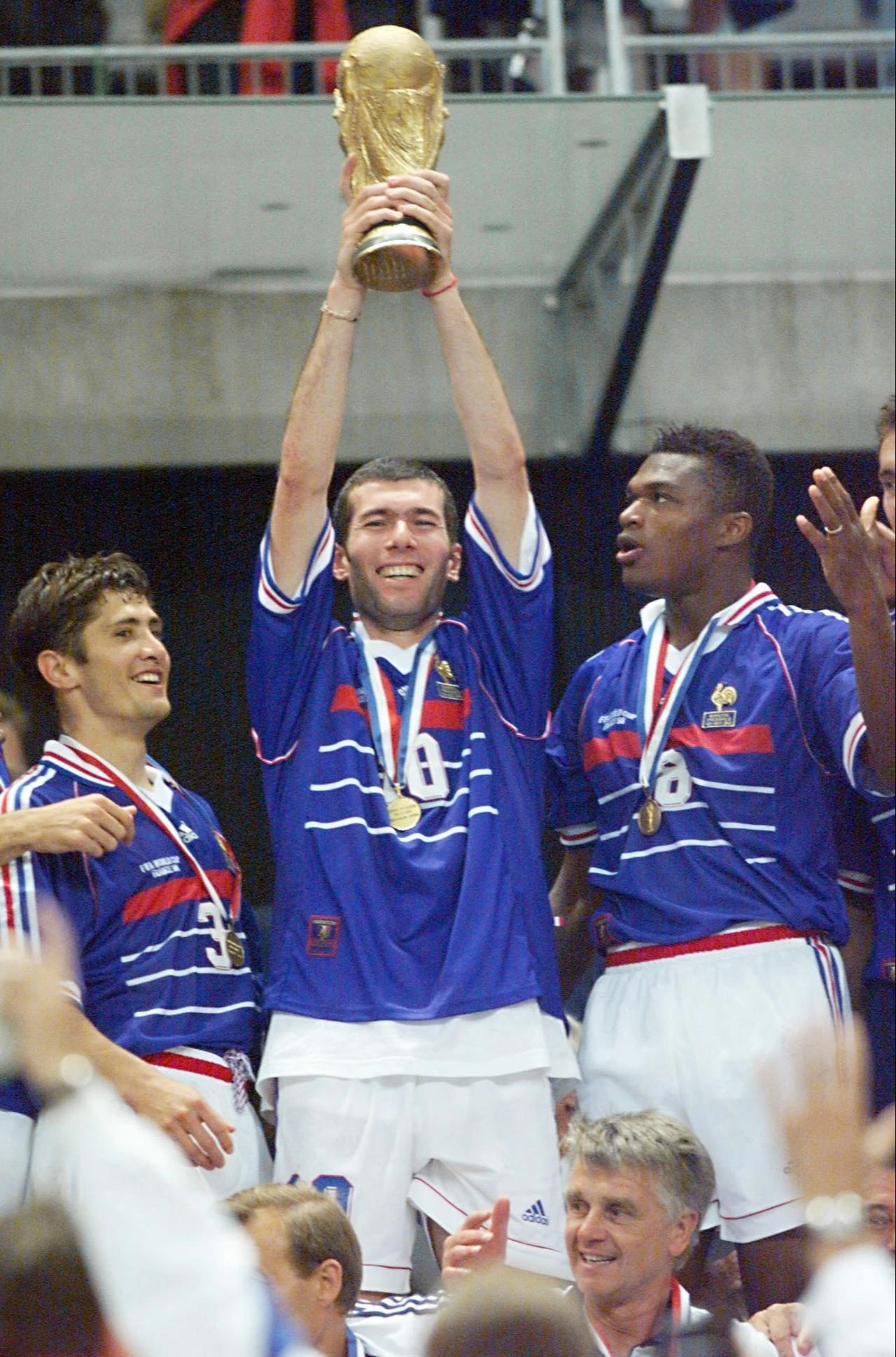 French players Bixente Lizarazu (L) and Marcel Desailly (R) smile as Zinedine Zidane holds the FIFA Trophy at the Stade de France in France, July 12, 1998. (AFP Photo)