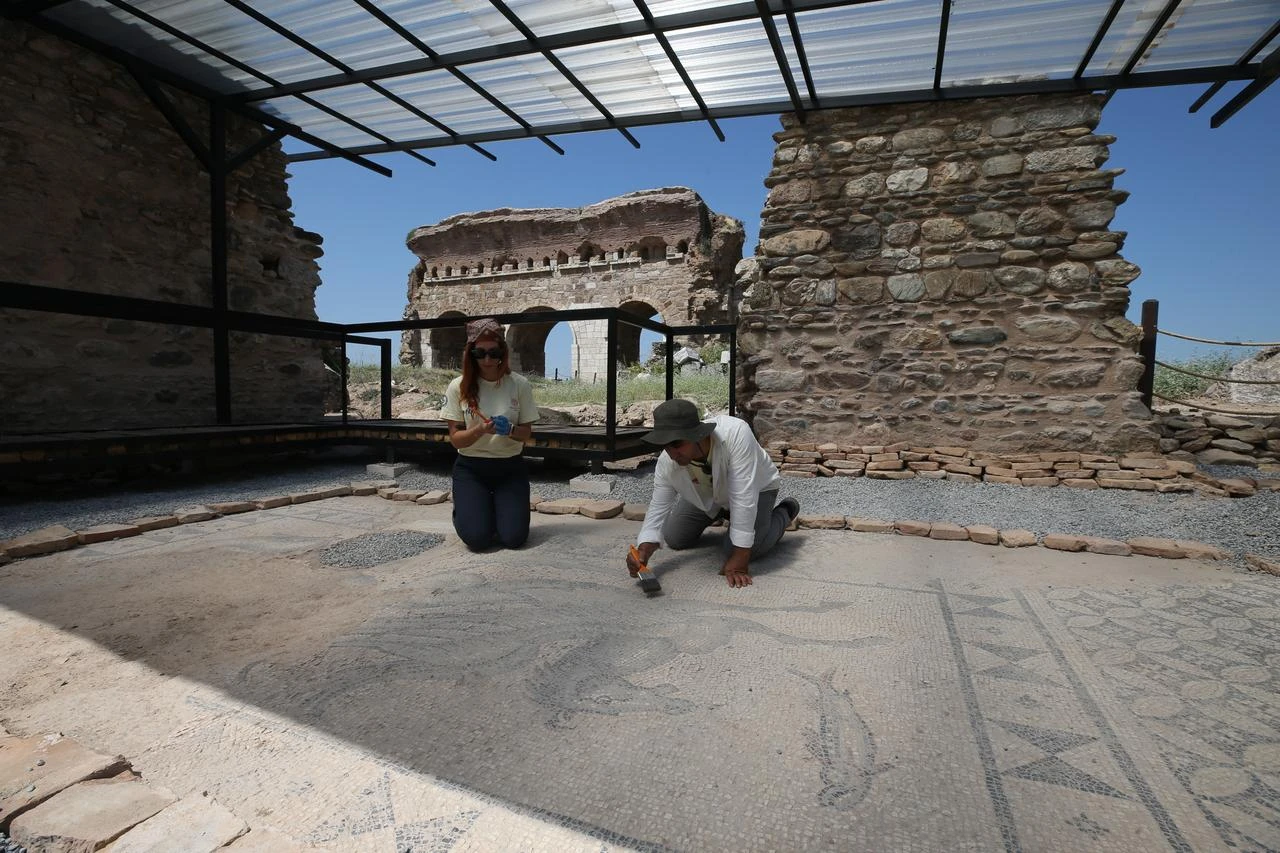 Archaeologists clean and document the approximately 2,000-year-old mosaic floor uncovered inside the bath-gymnasium complex at Tralleis ancient city in Aydin, western Türkiye. (AA Photo)