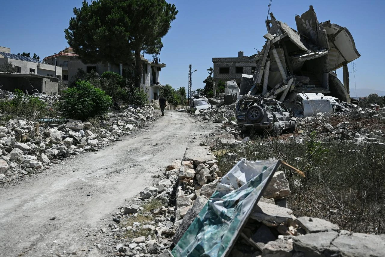 A man walks past damaged buildings in Zawtar al-Gharbiya on July 28, 2026, as residents check on their homes after the Lebanese army deployed to the southern village last week as part of a framework deal reached with Israel. (AFP Photo)