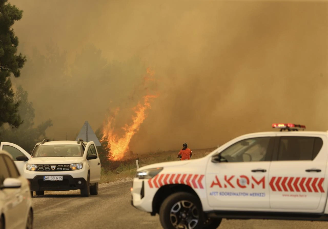 Fire crews and emergency vehicles operate along the Fethiye-Antalya highway as thick smoke from a forest fire reduces visibility in the Seydikemer district of Mugla, on July 29, 2026 in Mugla, Türkiye. (AA Photo)