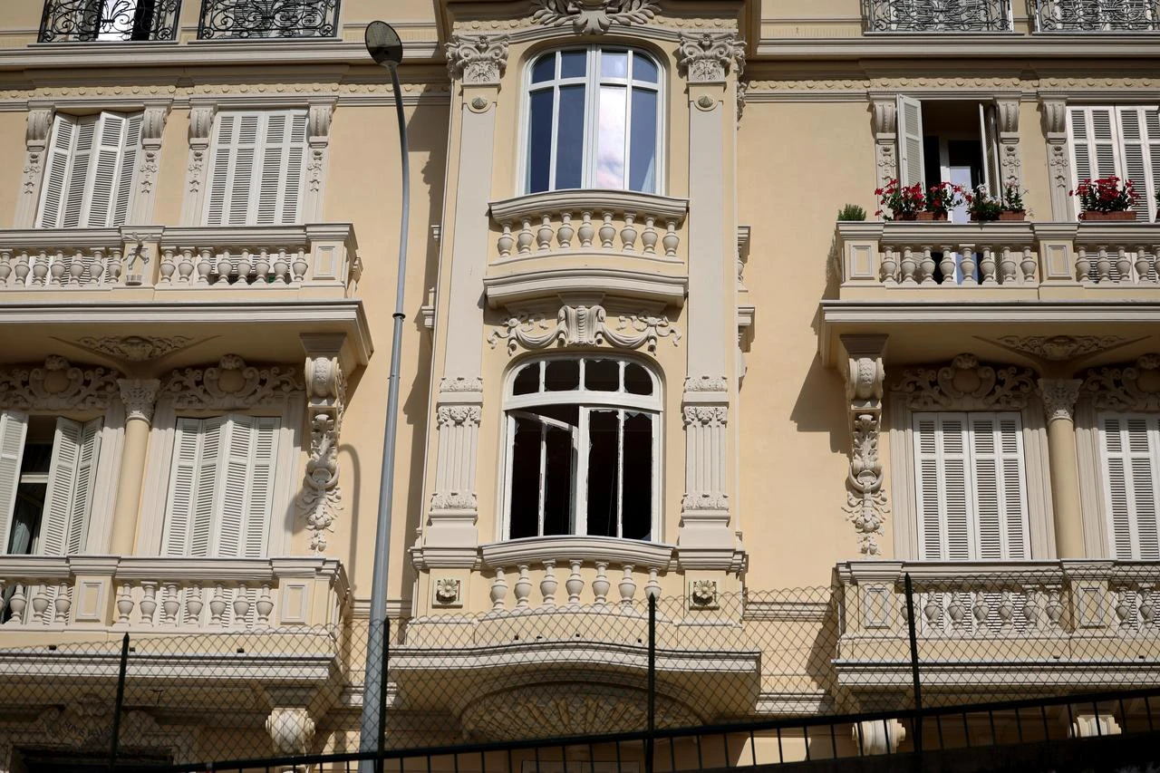 This photograph shows the shattered window of a residential building as a bomb disposal team operates at the scene in Monaco on June 30, 2026, a day after an attack involving an explosive device. (AFP Photo)