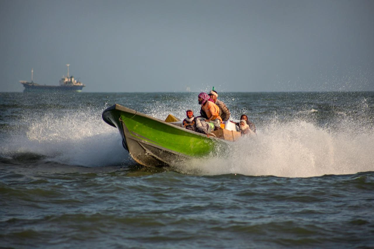 People unload goods from a small boat along the coast of Bandar Abbas, southern Iran, following a reduction in military tensions in the Strait of Hormuz on June 25, 2026. (AA Photo)