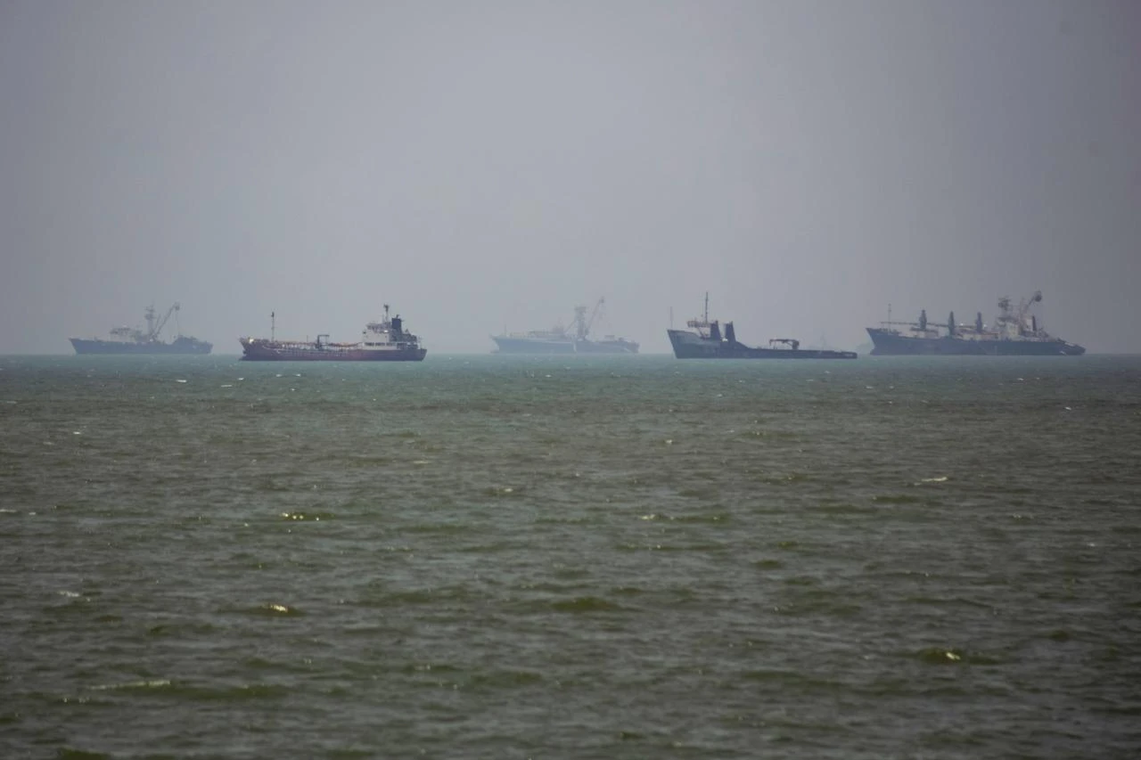 Large commercial vessels and a small boat navigate the waters off the southern port city of Bandar Abbas, Iran, on June 21, 2026. (AA Photo)