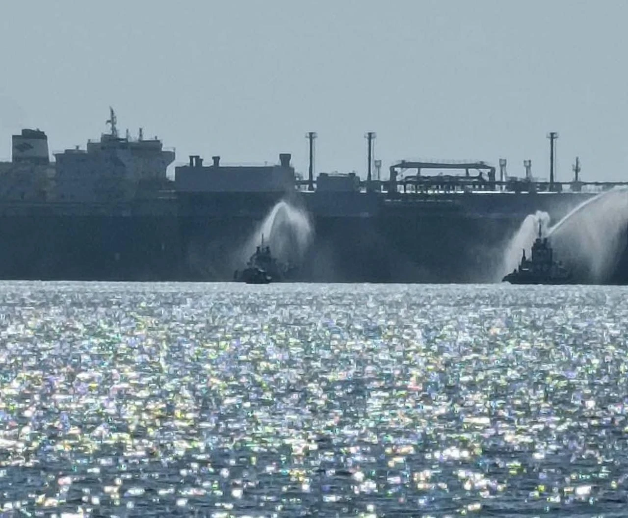 The photo shows boats trying to extinguish a fire on a U.S.-owned LNG tanker at Egypt's Damietta port on July 29, 2026. (Photo via Telegram)