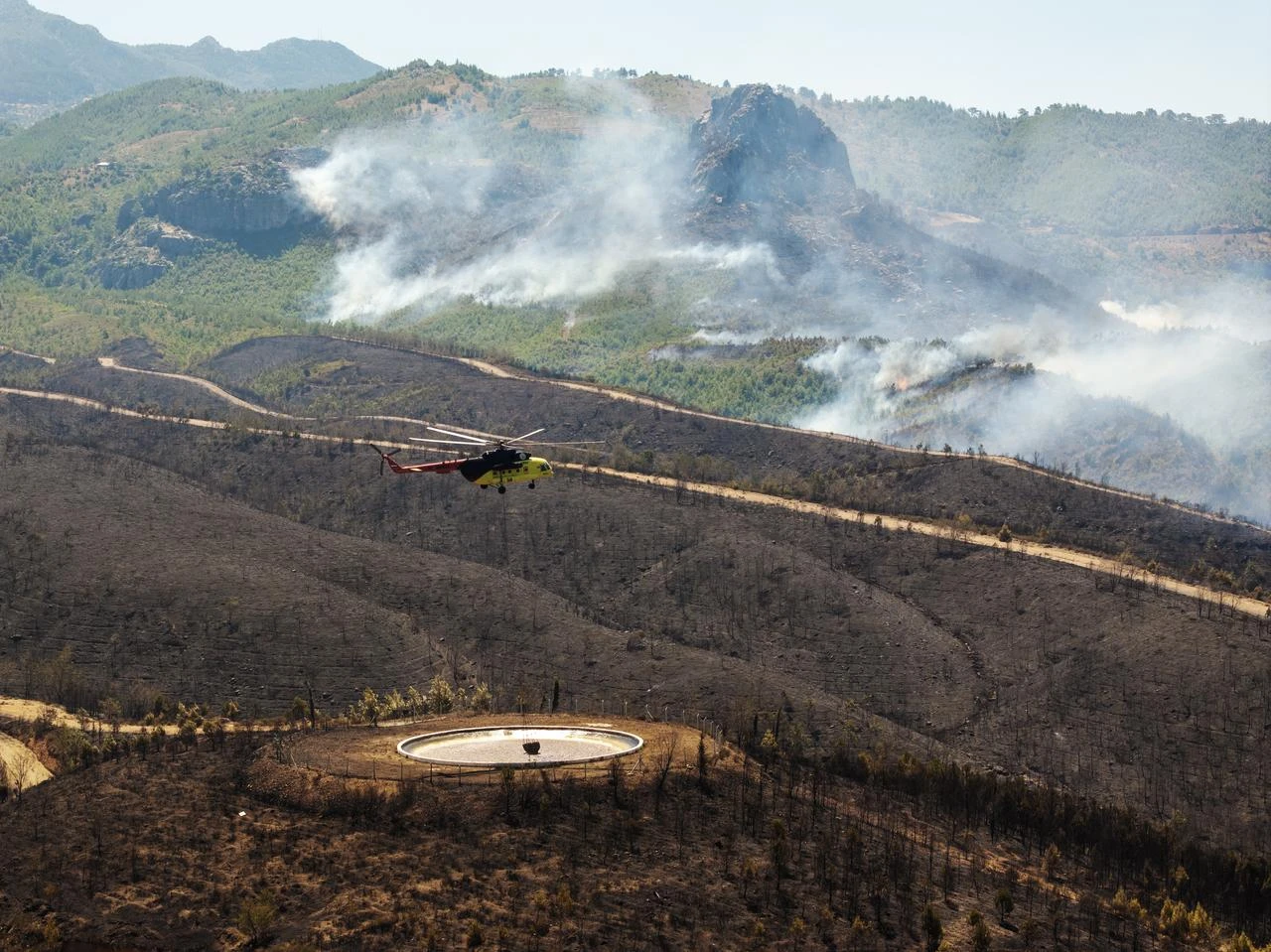 Fire extinguishing efforts continue both from the air and land to contain a wildfire in the Alanya district of Mugla, Türkiye on July 30, 2026. (AA Photo)