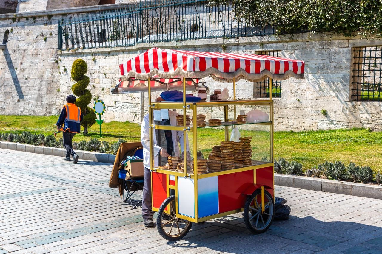A street vendor sells traditional Turkish simit from a cart near the historic Sultanahmet area in Istanbul, Türkiye. (Adobe Stock Photo)