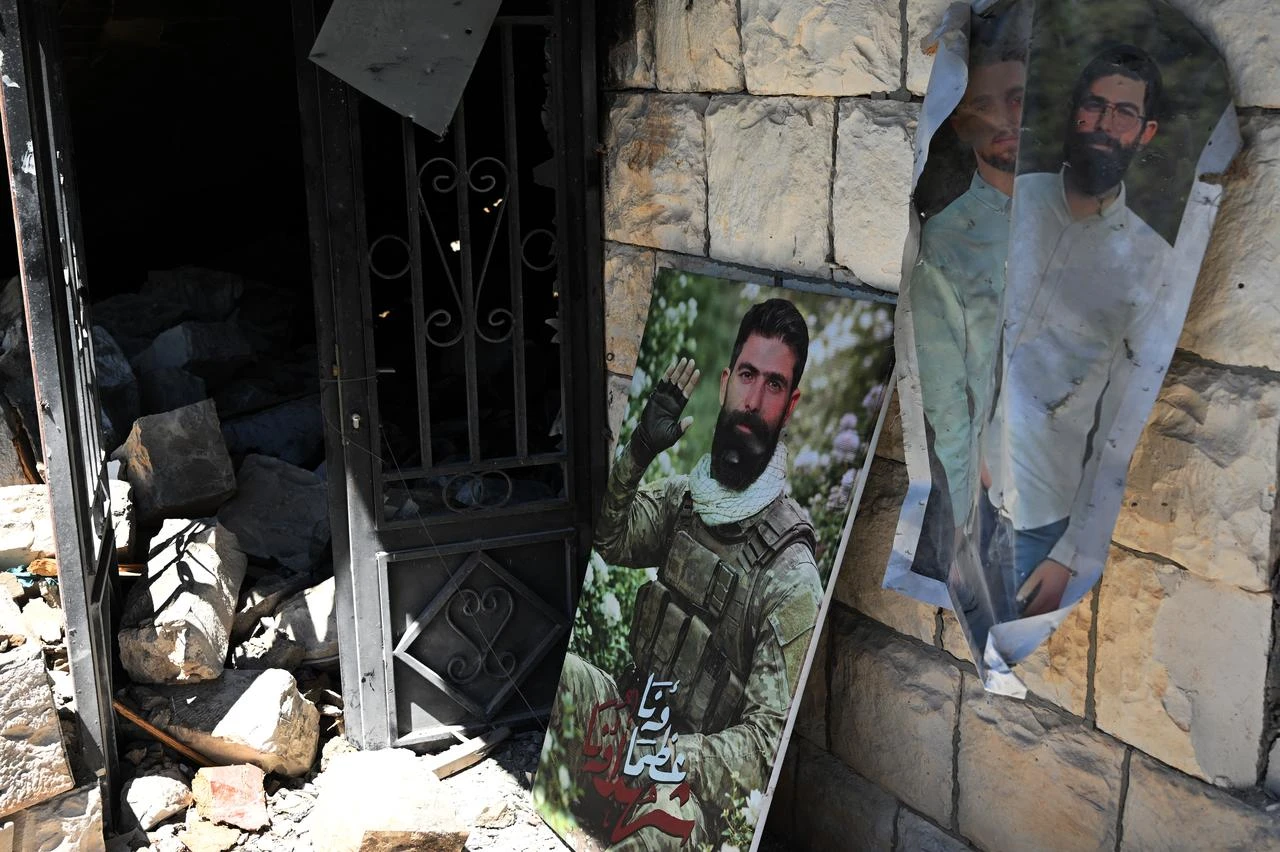 The portrait of a Hezbollah fighter killed during the conflict sits at the entrance of his family's destroyed home in Zawtar al-Gharbiya on July 28, 2026. (AFP Photo)