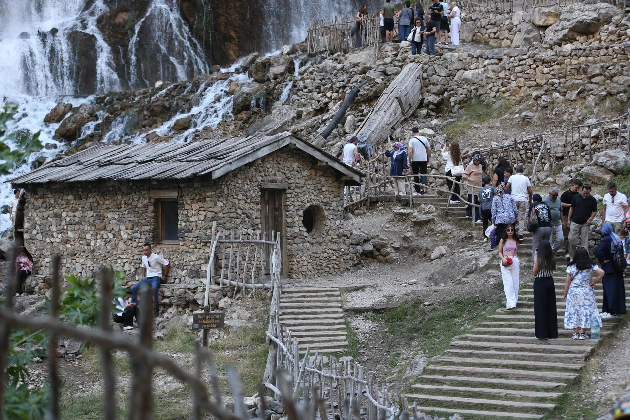 Visitors explore the century-old water mill beside Kapuzbaşı Waterfalls in Yahyalı, Kayseri, Türkiye, July 31, 2026. (AA Photo)