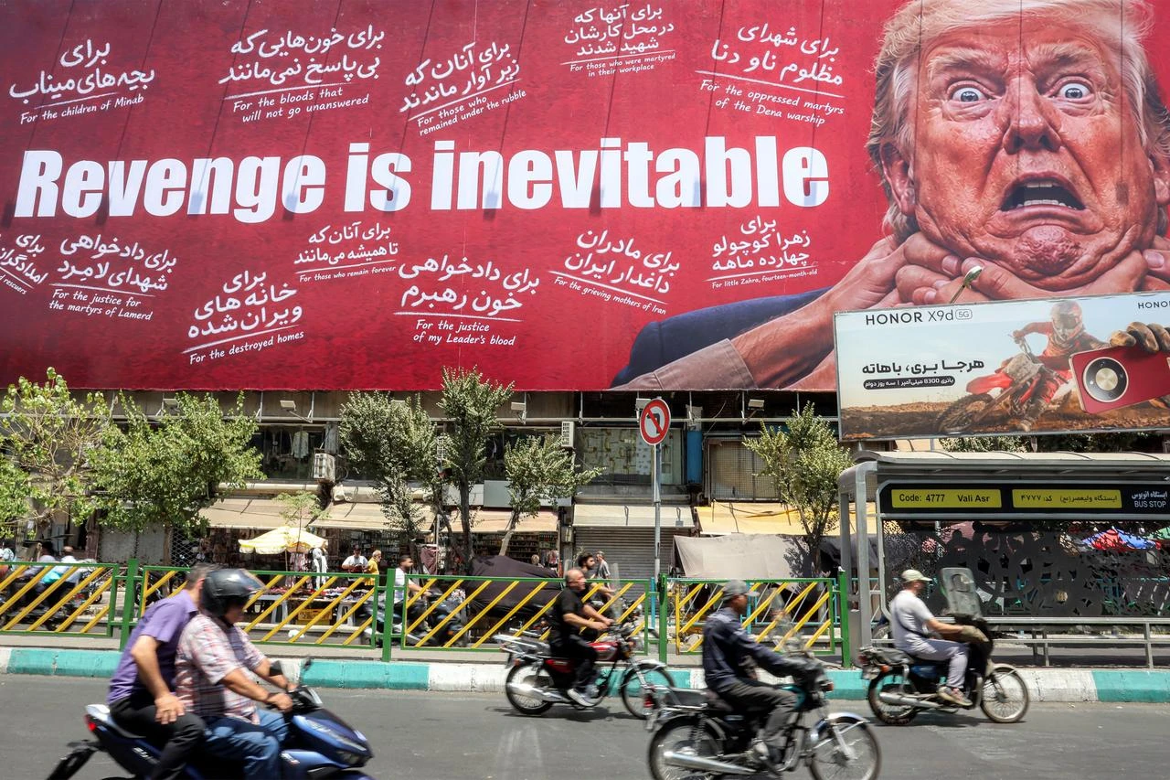 Motorists drive past a large billboard pledging revenge against US President Donald Trump along Jomhouri Street in central Tehran on July 27, 2026. (AFP Photo)