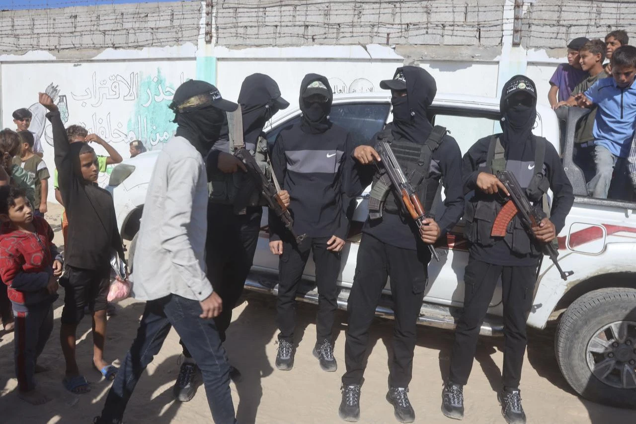 Hamas members observe the operation to recover the bodies of Israeli captives on October 26, 2025. (AA Photo)