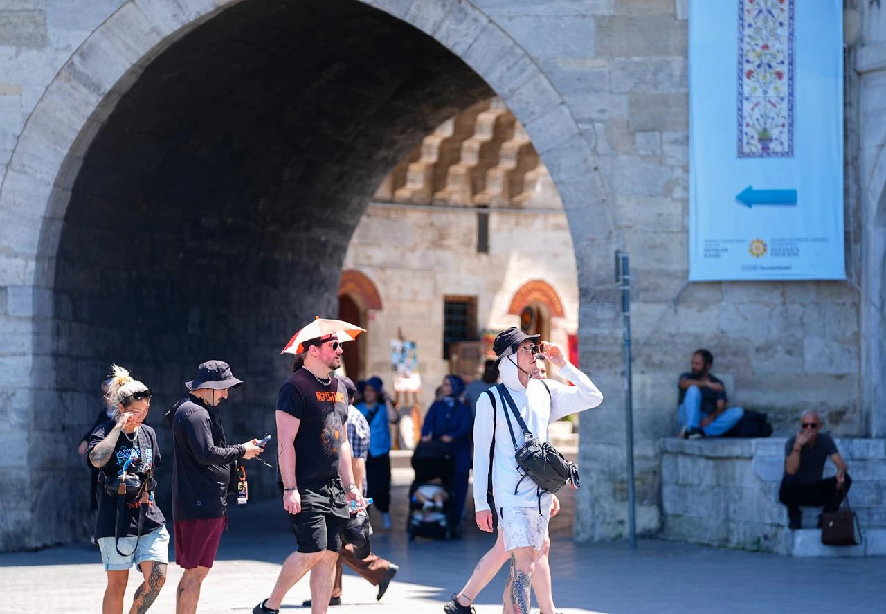 Tourists walk near a historic archway as hot weather affects Istanbul, Türkiye, June 29, 2026. (AA Photo)