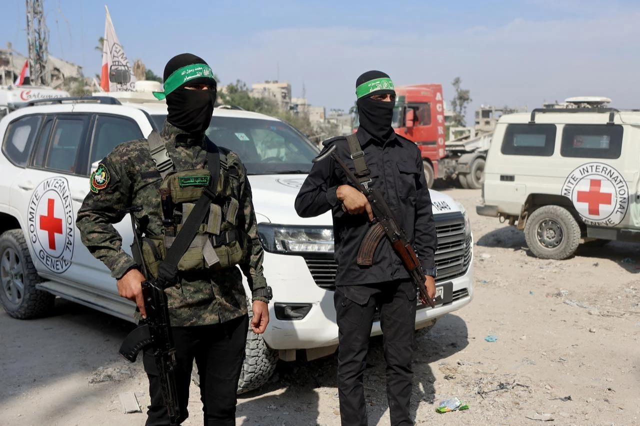 Palestinian Hamas members, along with members of the International Red Cross (ICRC), watch in Gaza City on November 2, 2025. (AFP Photo)