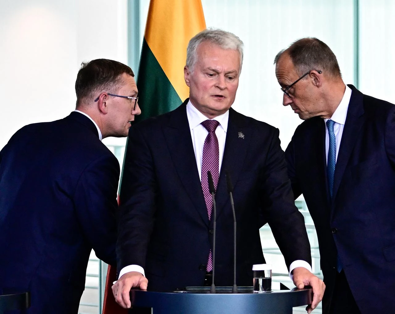 German Chancellor Friedrich Merz (R) bids farewell to Estonian Prime Minister Kristen Michal (L) while Lithuanian President Gitanas Nauseda (C) addresses a joint press conference after a meeting at the Chancellery in Berlin on July 3, 2026. (AFP Photo)