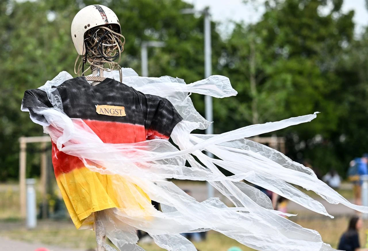 A figure with a shirt in colours of the German flag bears a sign with the lettering "Fear" near the Messe Erfurt fairground in Erfurt, eastern Germany on July 4, 2026. (AFP Photo)