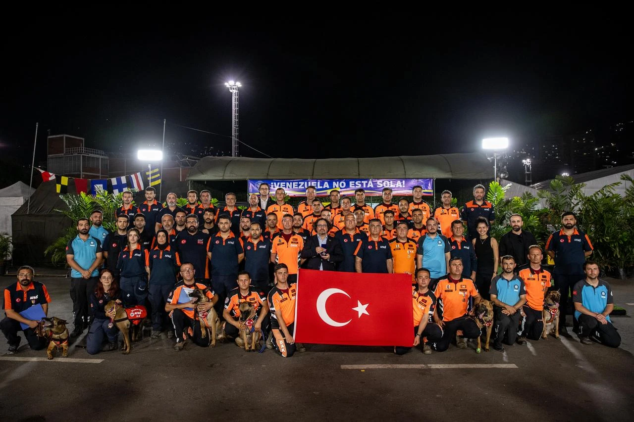 Turkish search and rescue teams pose with a Turkish flag and K9 dogs after receiving heroism medals from Venezuela’s interim President Delcy Rodriguez in Venezuela, July 4, 2026. (AA Photo)