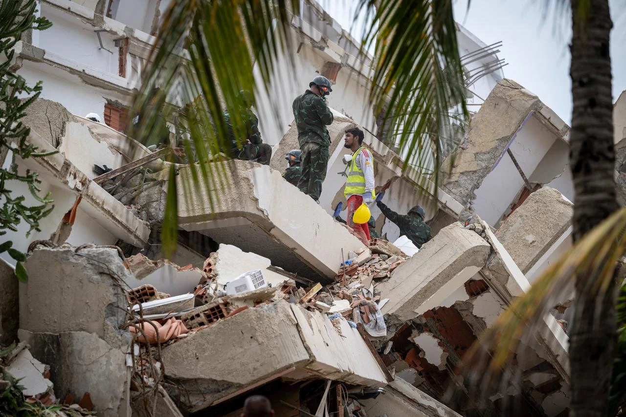 A Venezuelan volunteer speaks with a Vietnamese rescuer amid the rubble of a destroyed building in La Guaira, Venezuela, July 3, 2026. (AFP Photo)